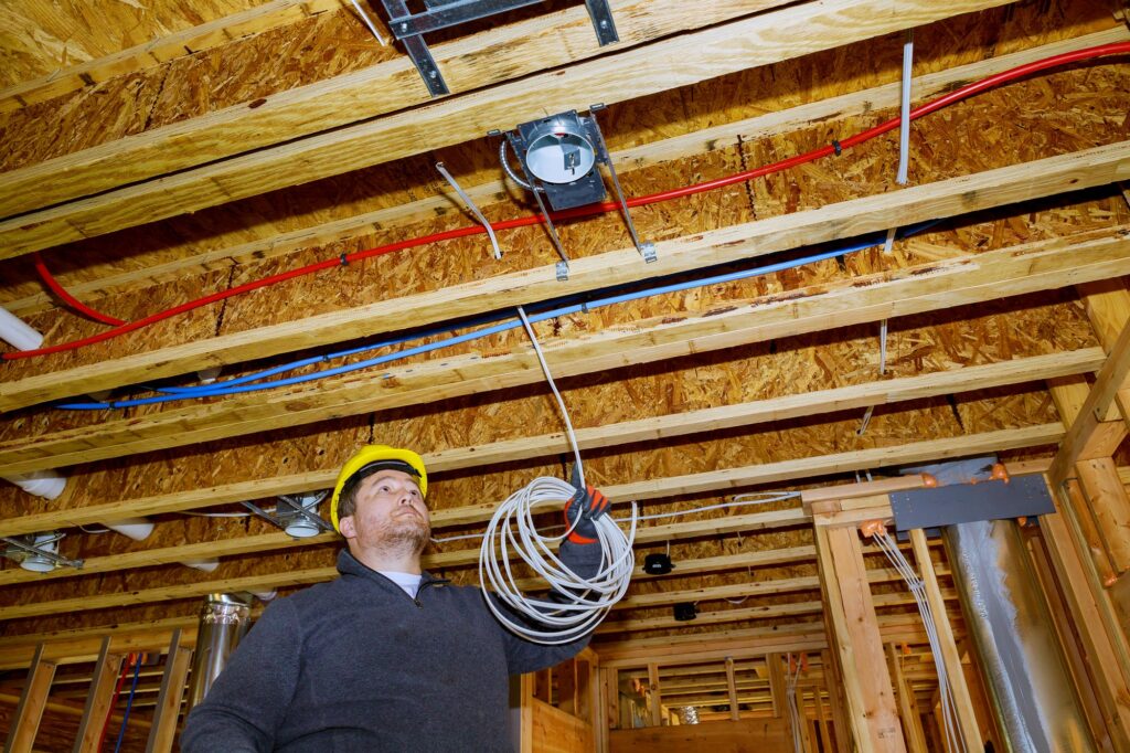 Electrician working with wires electrician mounts in new home